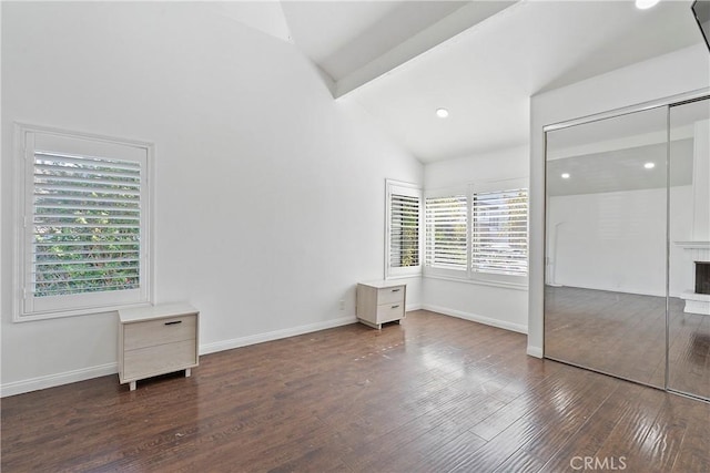 unfurnished bedroom with multiple windows, a closet, dark hardwood / wood-style flooring, and vaulted ceiling with beams