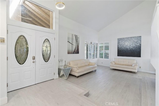 foyer entrance featuring high vaulted ceiling and light hardwood / wood-style flooring