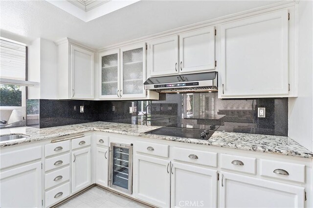 kitchen featuring white cabinetry, decorative backsplash, and wine cooler