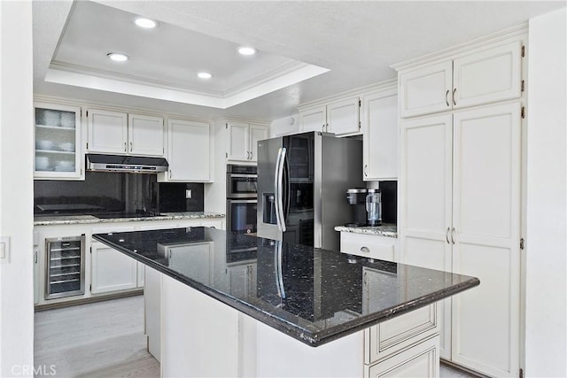 kitchen with stainless steel appliances, white cabinetry, a raised ceiling, and wine cooler