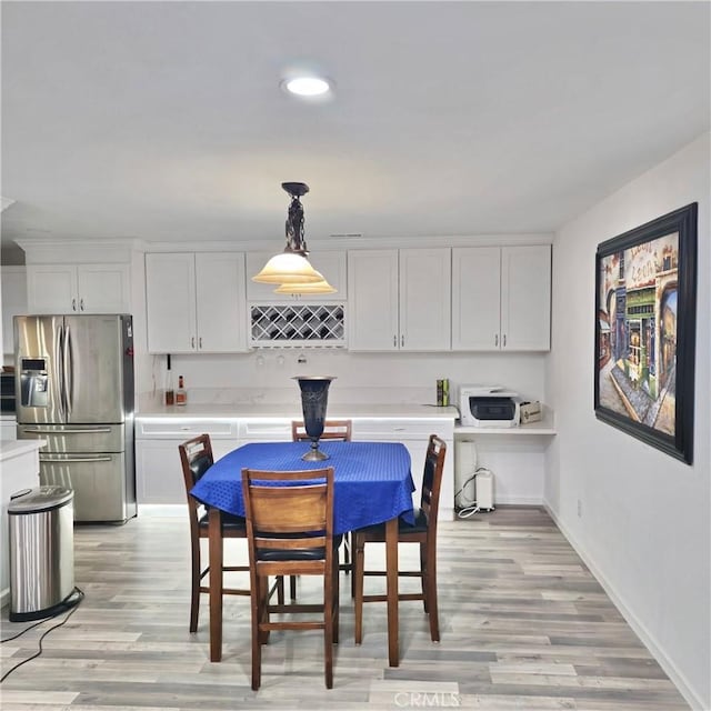 dining space with light wood finished floors, baseboards, and recessed lighting