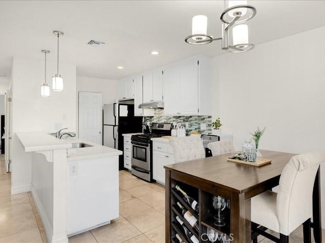 kitchen featuring pendant lighting, stainless steel gas range, white cabinetry, sink, and light tile patterned flooring