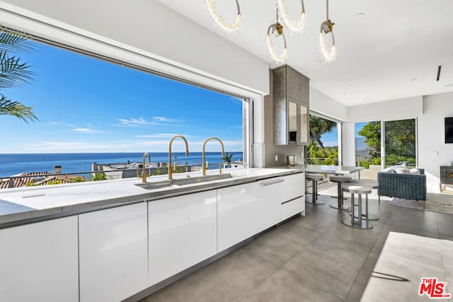 view of patio with sink, a water view, and an outdoor living space