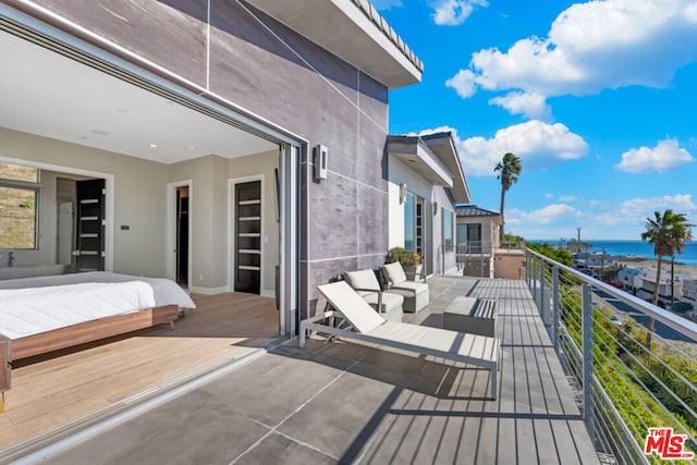 deck featuring a water view and outdoor lounge area