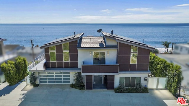 exterior space with solar panels, a water view, and a garage