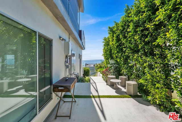 balcony with a patio and a water view