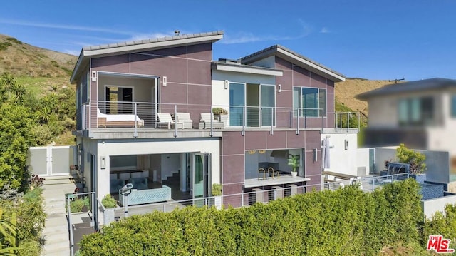 back of house featuring a balcony and a mountain view