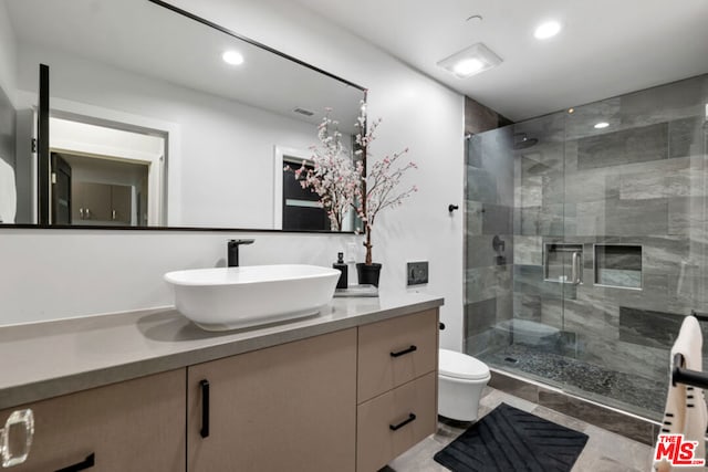 bathroom with toilet, walk in shower, tile patterned floors, and vanity