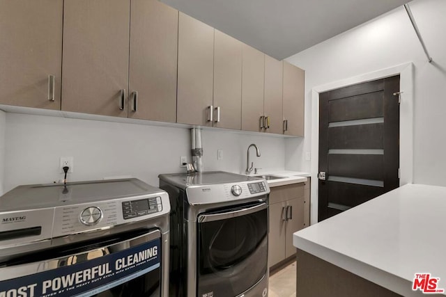 laundry area with cabinets, sink, and washer and clothes dryer