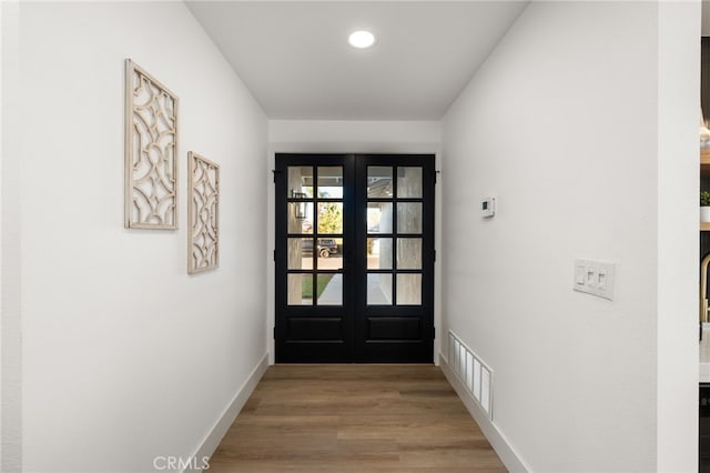 entryway with wood-type flooring and french doors