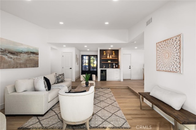 living room with bar area, wine cooler, and wood-type flooring