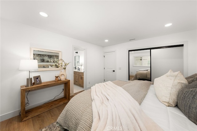 bedroom with light hardwood / wood-style floors and connected bathroom