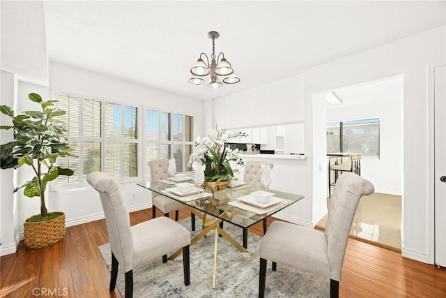 dining area with an inviting chandelier and wood-type flooring