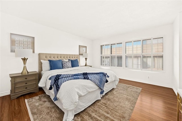 bedroom featuring multiple windows and dark hardwood / wood-style floors