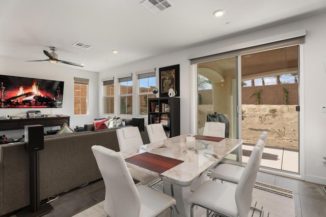 dining space with ceiling fan and light tile patterned flooring