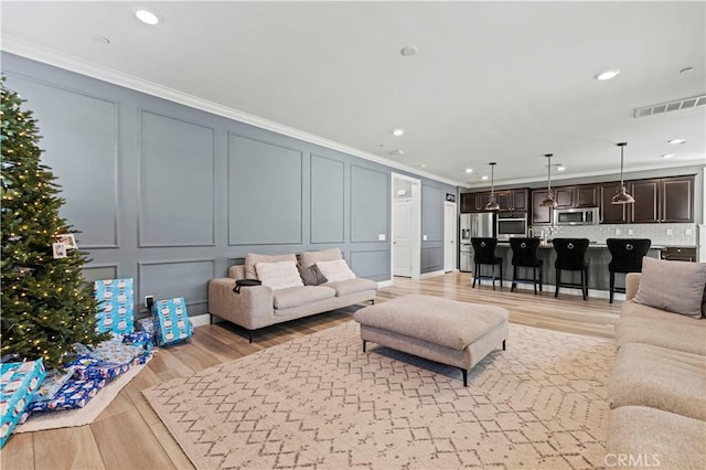 living room featuring light hardwood / wood-style floors and ornamental molding