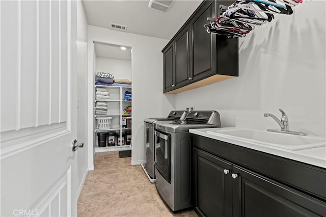 clothes washing area featuring sink, independent washer and dryer, cabinets, and light tile patterned floors