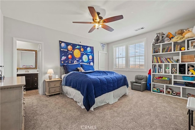 carpeted bedroom featuring ceiling fan, sink, and ensuite bath