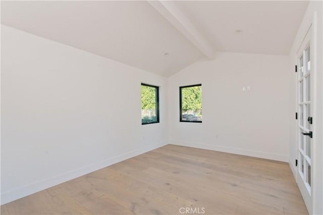 unfurnished room with vaulted ceiling with beams and light hardwood / wood-style flooring