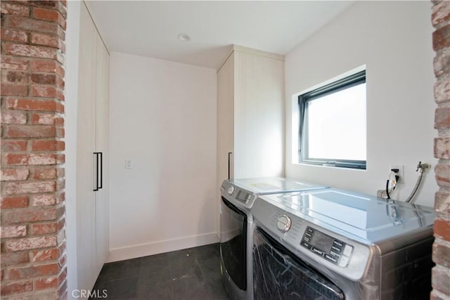 laundry room featuring washer and clothes dryer and dark tile patterned floors