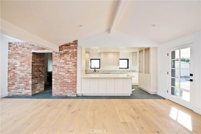 kitchen with hardwood / wood-style flooring, a healthy amount of sunlight, and vaulted ceiling with beams