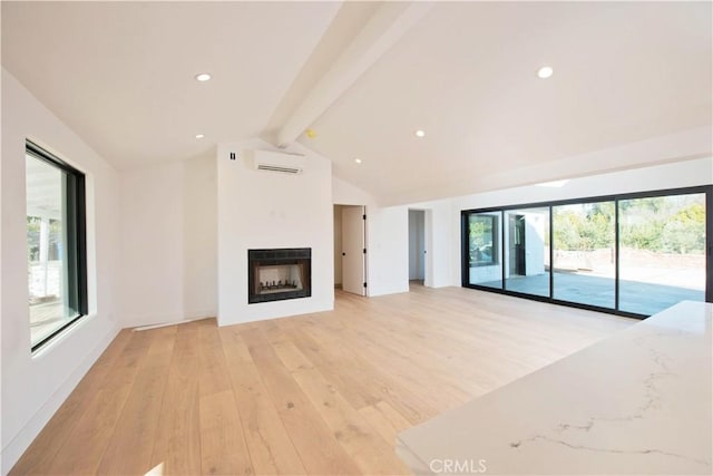 unfurnished living room featuring lofted ceiling with beams, a wall unit AC, and light wood-type flooring