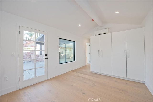 unfurnished bedroom with access to exterior, a wall mounted AC, lofted ceiling with beams, and light hardwood / wood-style flooring