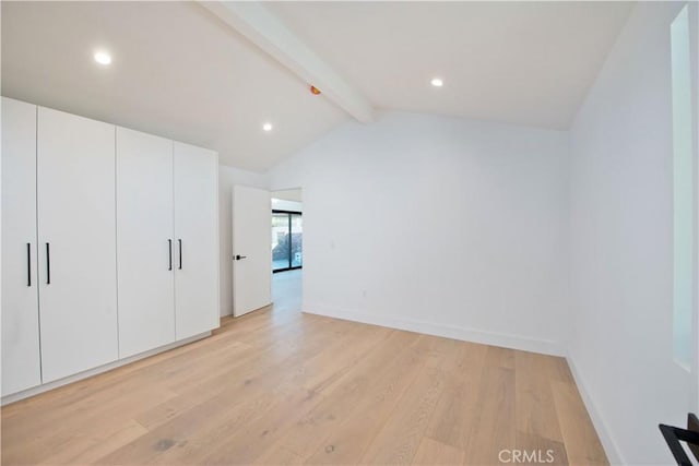 unfurnished bedroom featuring vaulted ceiling with beams and light hardwood / wood-style flooring