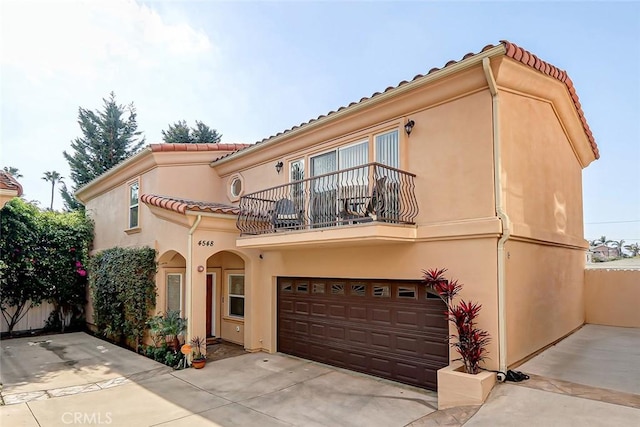 mediterranean / spanish house featuring a balcony and a garage