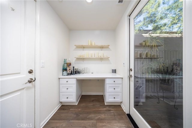 interior space with built in desk and dark wood-type flooring