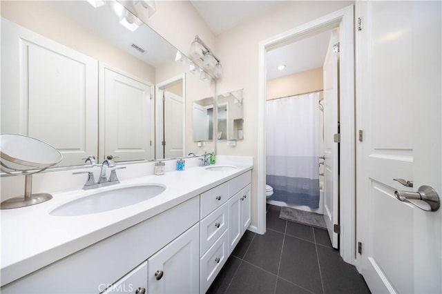 bathroom featuring toilet, vanity, and tile patterned flooring