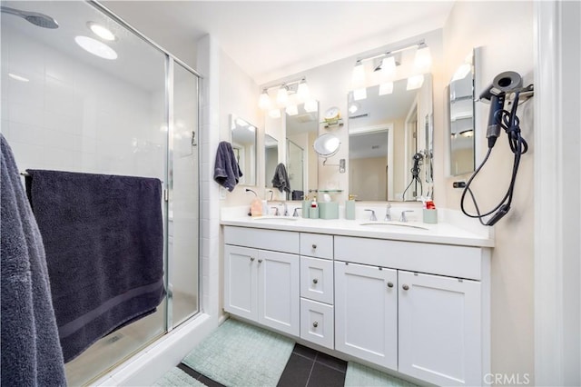 bathroom with vanity, a shower with shower door, and tile patterned flooring