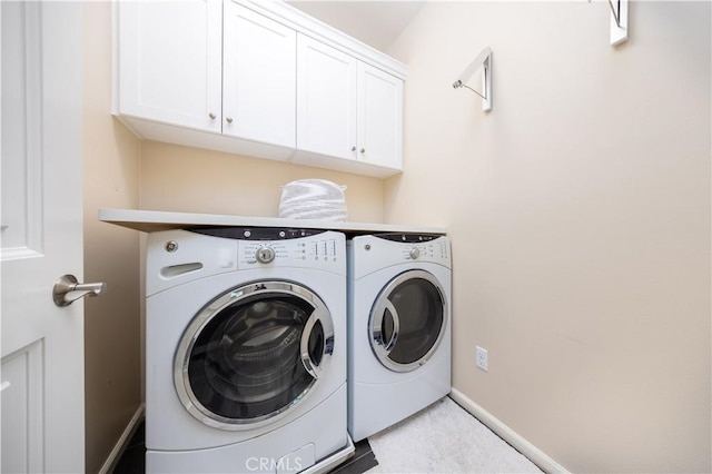 washroom featuring cabinets and washer and clothes dryer