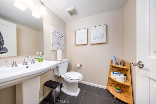 bathroom with sink, toilet, and tile patterned flooring