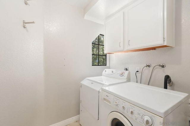 washroom featuring cabinets and independent washer and dryer