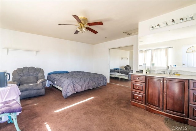 carpeted bedroom featuring ceiling fan, sink, and a closet