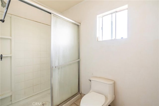 bathroom featuring toilet and an enclosed shower