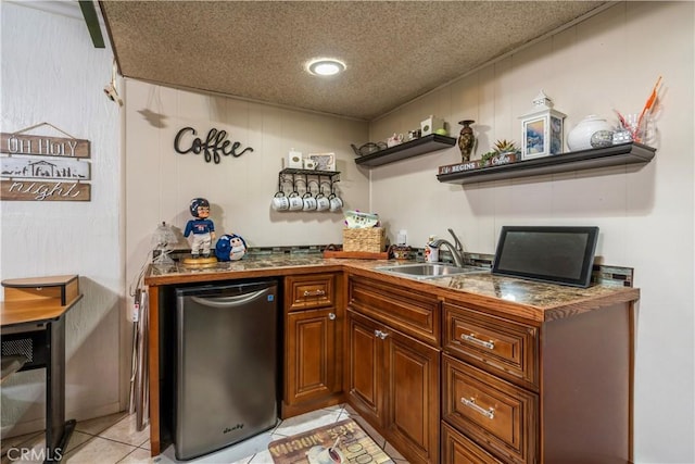 bar with light tile patterned flooring, refrigerator, sink, and a textured ceiling