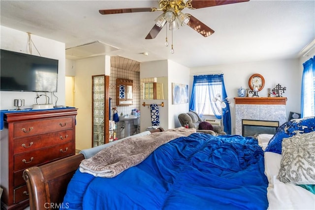 bedroom featuring ceiling fan and a fireplace