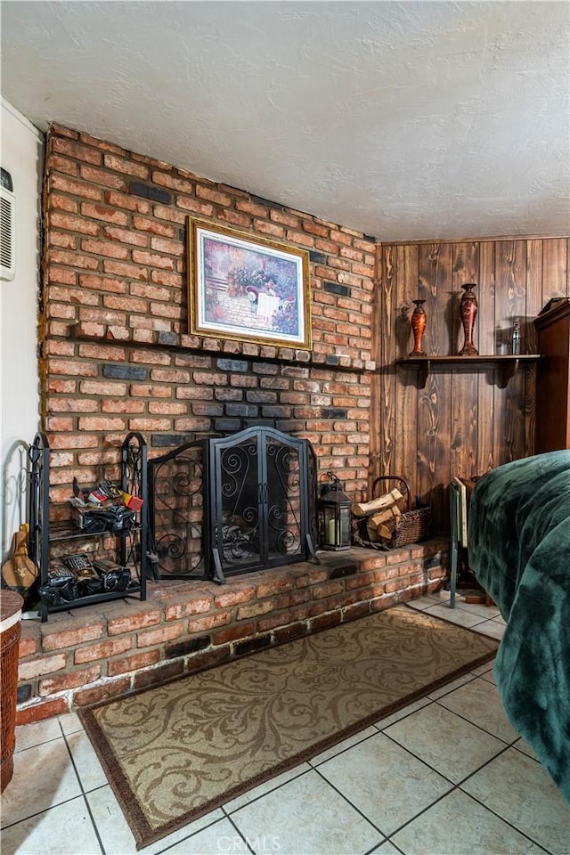 tiled living room featuring a textured ceiling, a fireplace, and wooden walls