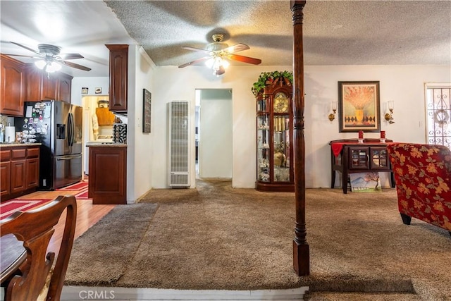 interior space featuring light carpet, ceiling fan, and a textured ceiling