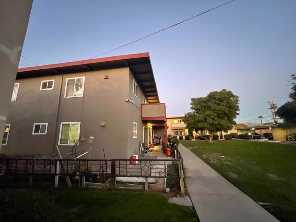 back house at dusk featuring a lawn