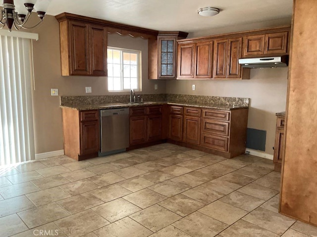 kitchen featuring sink, stainless steel dishwasher, dark stone counters, and an inviting chandelier