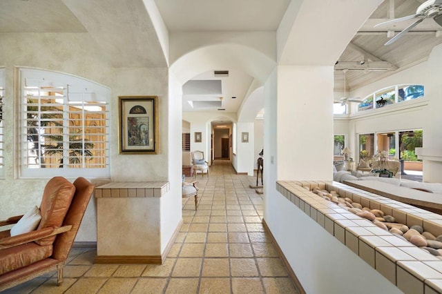 corridor featuring beamed ceiling and a high ceiling