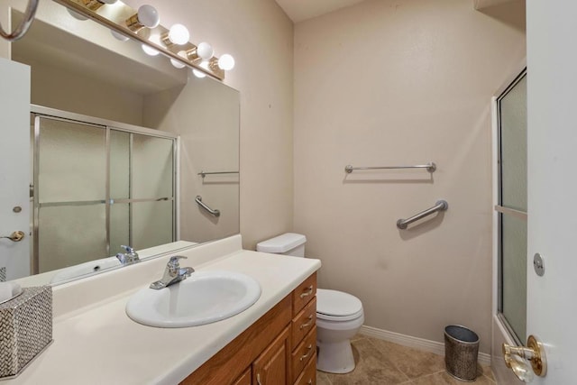 bathroom featuring toilet, a shower with shower door, tile patterned floors, and vanity