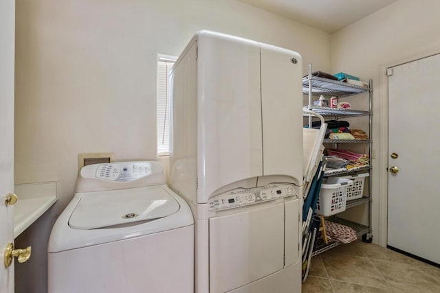 laundry area with washing machine and dryer and light tile patterned floors