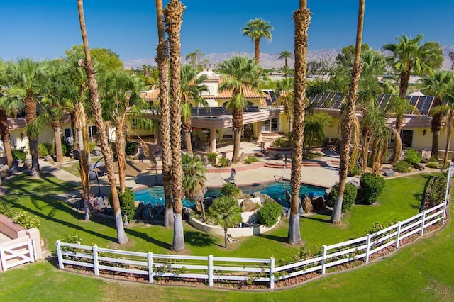 view of community with a pool, a mountain view, and a lawn