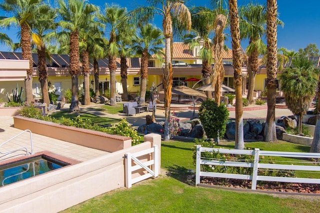 view of community featuring a swimming pool, a patio, and a lawn