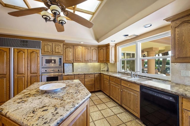 kitchen featuring light stone countertops, sink, built in appliances, and tasteful backsplash