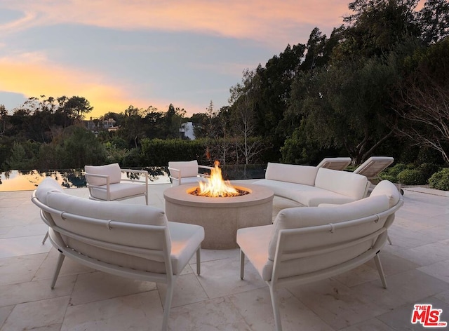 patio terrace at dusk featuring an outdoor living space with a fire pit